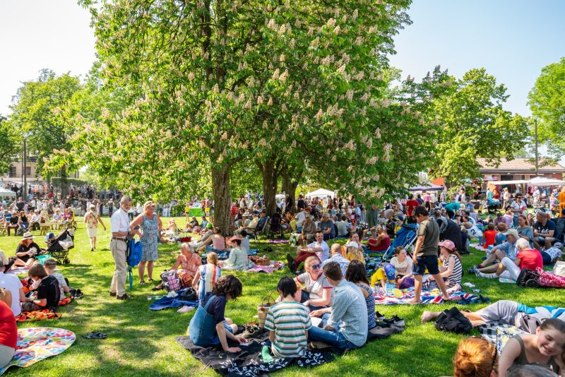 Jakobsberg, Sweden - June 6, 2019: Close-up summer garden view of groups with many people and families outdoors at a green field having picnic on the Swedish national day. Diversity with mixed ages in Jakobsberg Sweden June 6, 2019.